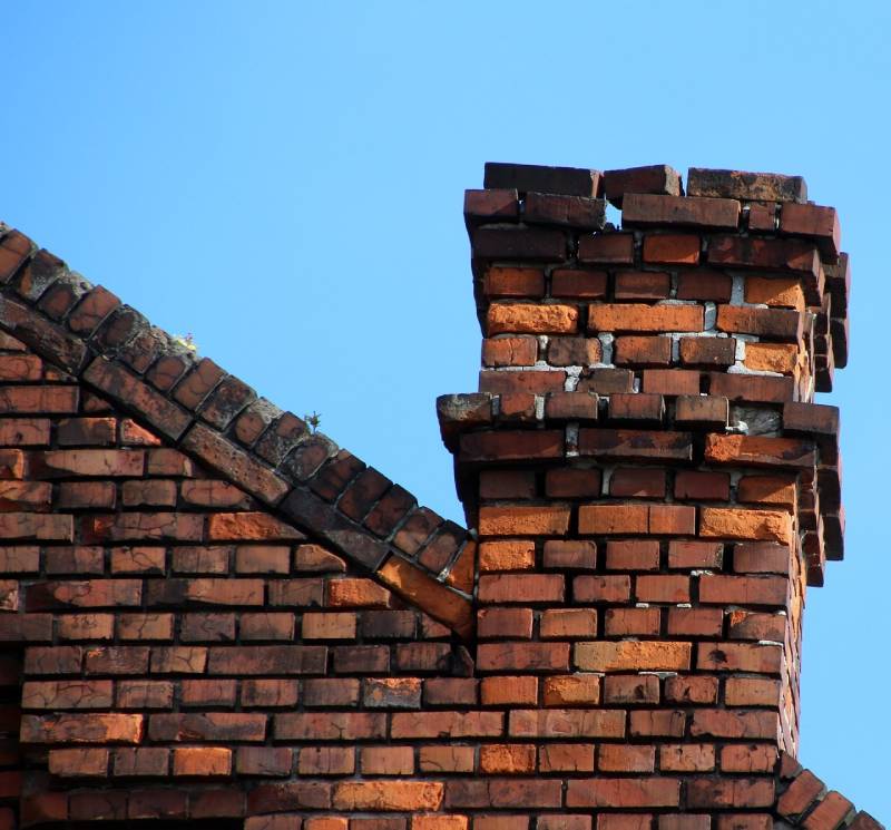 Damaged chimney on an Countryside home showing cracks and missing mortar